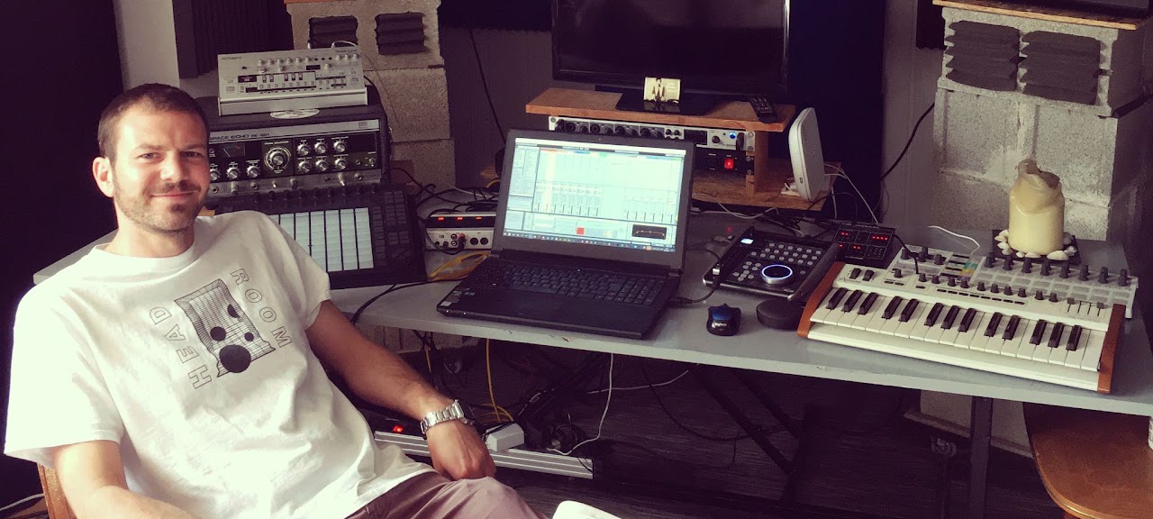James Rial in his studio surrounded by synths and production gear